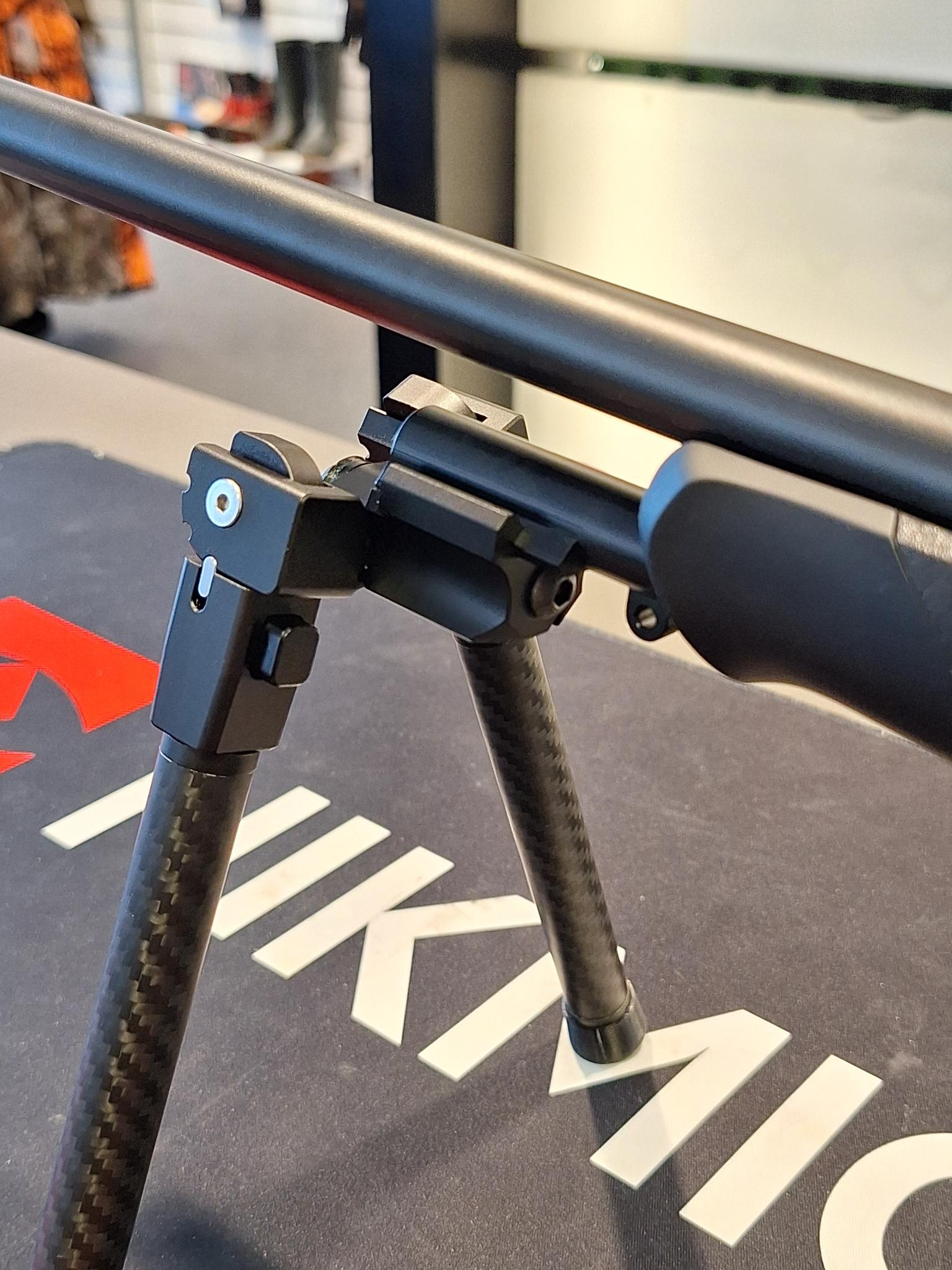 Picatinny adapter for Sauer 404/505 mounted on a rifle with bipod on display.
