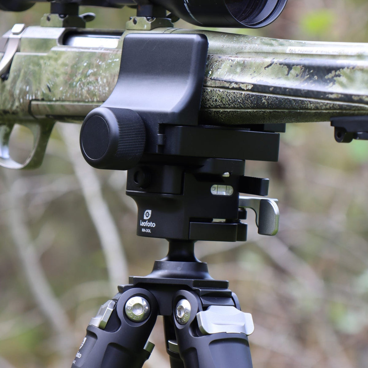 Close-up of a Leofoto GS-3 clamp supporting a camouflage rifle forend on a tripod head
